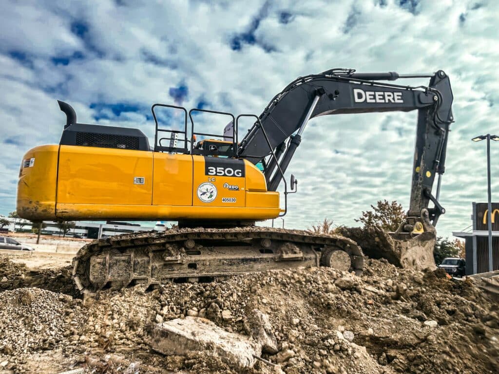Yellow excavator digging soil at an active construction site