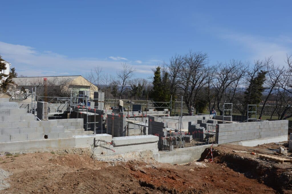 Skilled construction workers building a commercial project with concrete block walls, highlighting strategic workforce solutions for successful construction.